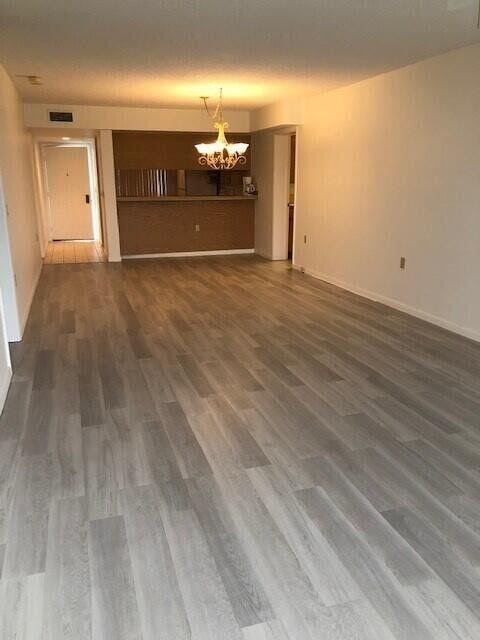 unfurnished living room featuring dark hardwood / wood-style floors and a notable chandelier