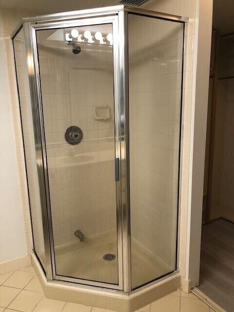 bathroom featuring a shower with shower door and tile patterned flooring