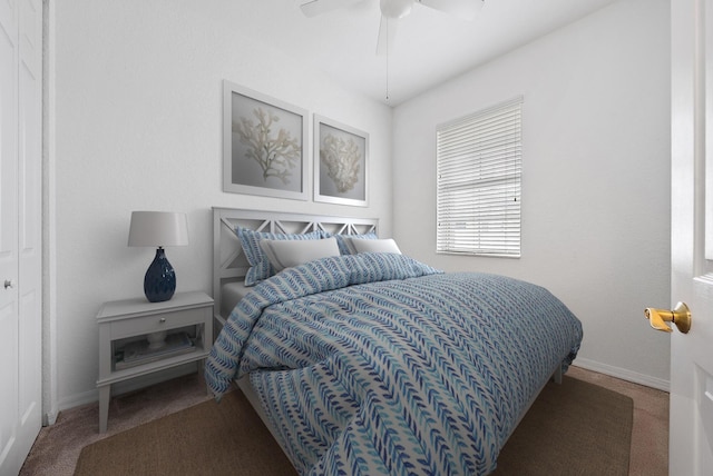 carpeted bedroom with ceiling fan and baseboards