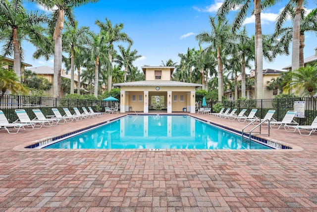 community pool with a patio and fence