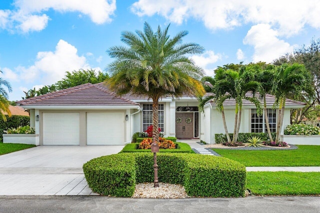 view of front of house with a tile roof, driveway, an attached garage, and stucco siding