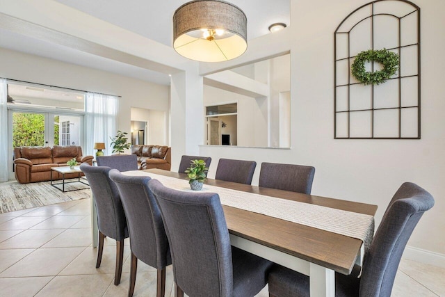 dining space featuring baseboards, french doors, and light tile patterned flooring