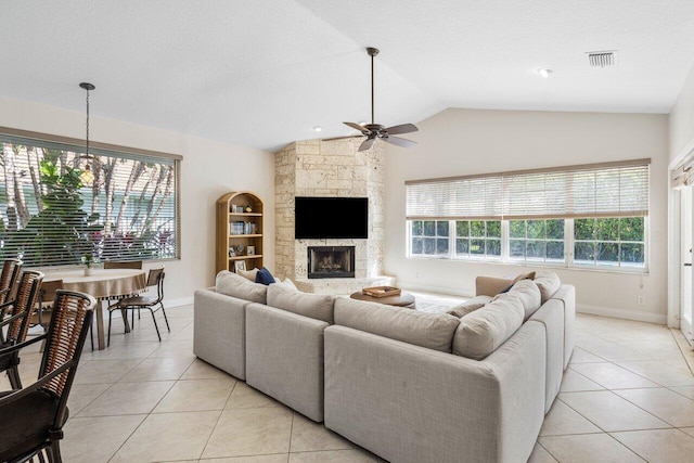 living area featuring lofted ceiling, light tile patterned flooring, a fireplace, and ceiling fan