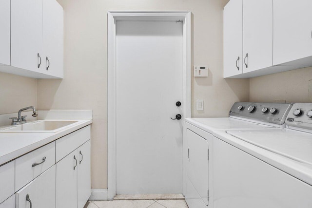 clothes washing area with light tile patterned floors, a sink, cabinet space, and washer and dryer