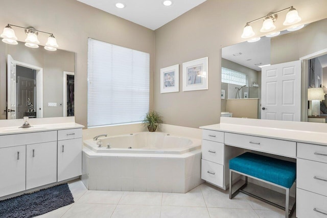 bathroom featuring tile patterned flooring, vanity, a tub with jets, and a walk in shower