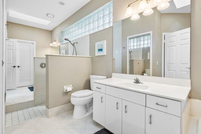 full bath featuring toilet, vanity, a walk in shower, and tile patterned floors