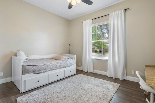 bedroom with a ceiling fan, baseboards, and wood finished floors