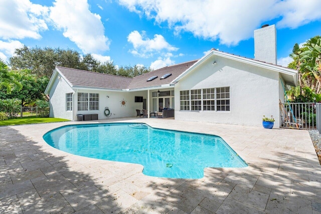 outdoor pool with a patio and fence