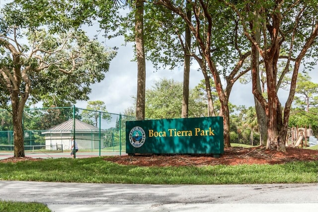 view of property's community with a tennis court and fence