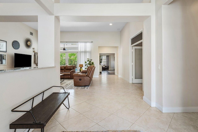 corridor with light tile patterned floors and baseboards