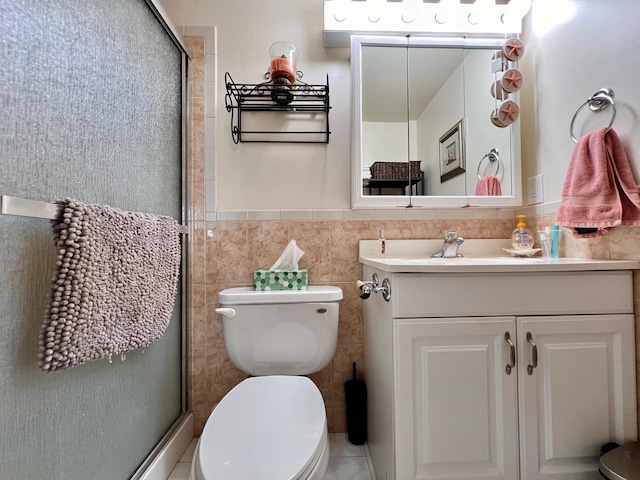 full bath featuring toilet, a wainscoted wall, vanity, tile walls, and a shower stall