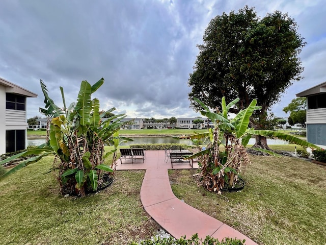 surrounding community featuring a water view, a yard, and a patio