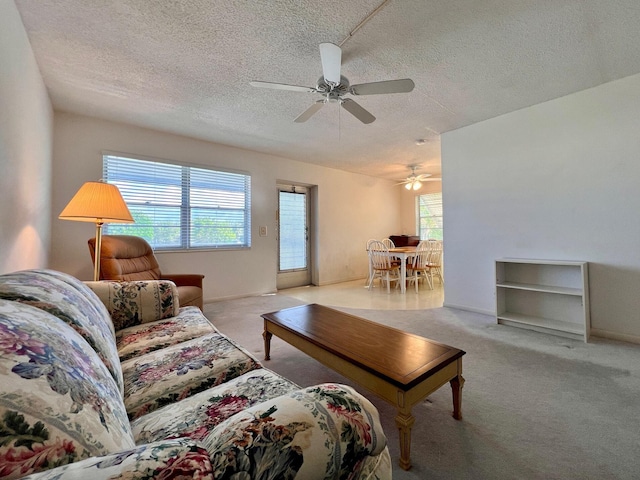 carpeted living room with ceiling fan, a textured ceiling, and a wealth of natural light