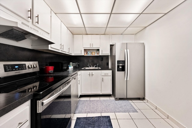 kitchen featuring appliances with stainless steel finishes, a paneled ceiling, sink, white cabinets, and light tile patterned floors