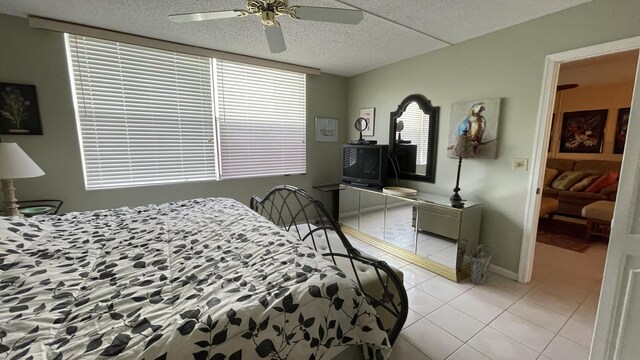 14623 Bonaire Blvd Unit 605, Delray Beach, FL 33446 - bedroom with light tile patterned flooring, a ceiling fan, and a textured ceiling