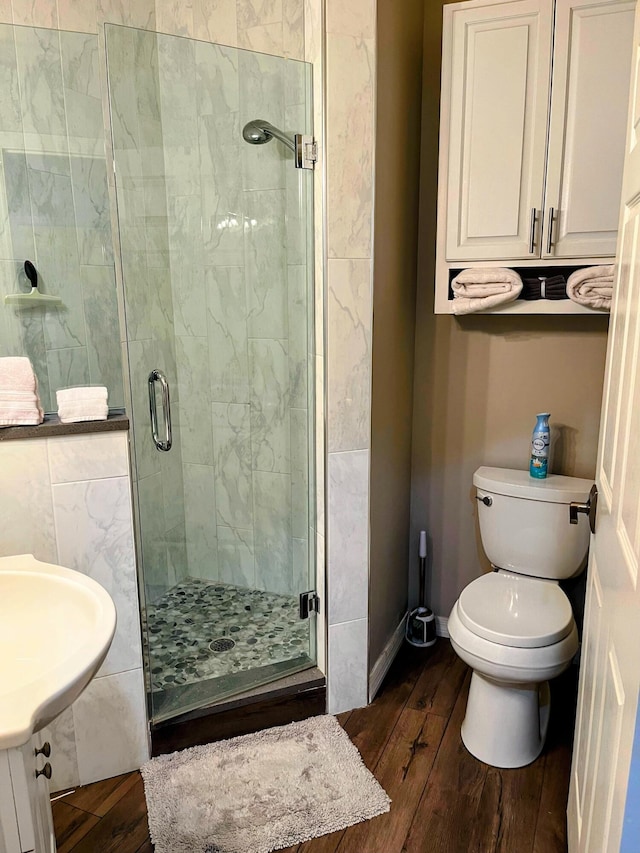 bathroom with hardwood / wood-style flooring, sink, toilet, and walk in shower