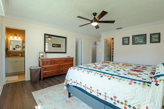 bedroom with crown molding, ceiling fan, dark hardwood / wood-style floors, connected bathroom, and a textured ceiling