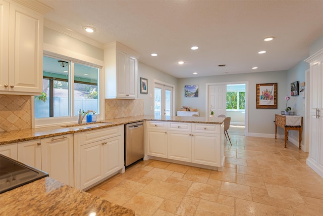 kitchen with sink, dishwasher, white cabinetry, light stone counters, and kitchen peninsula