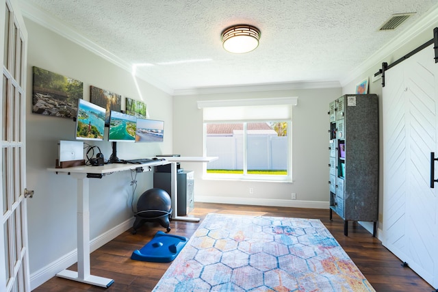 exercise area featuring ornamental molding, a barn door, a textured ceiling, and dark hardwood / wood-style flooring