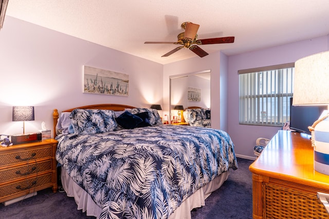 bedroom with ceiling fan, a textured ceiling, and dark carpet