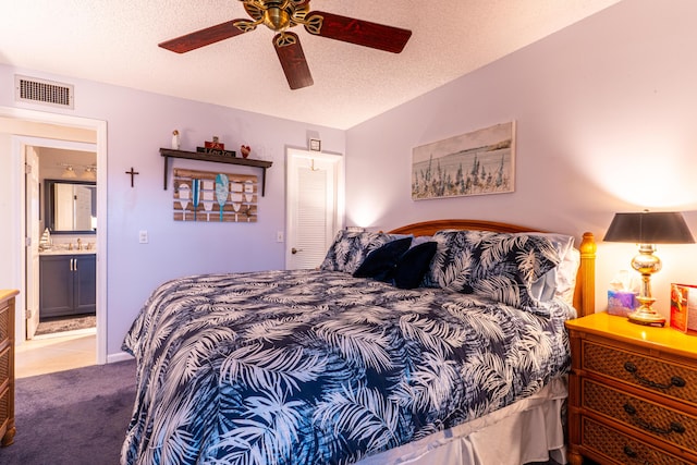 carpeted bedroom featuring ceiling fan and a textured ceiling