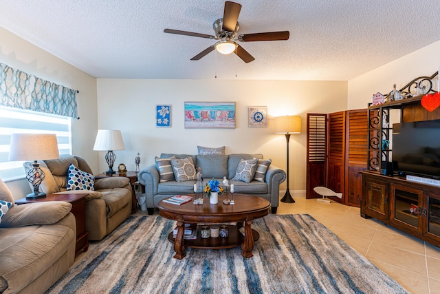 tiled living room featuring ceiling fan and a textured ceiling