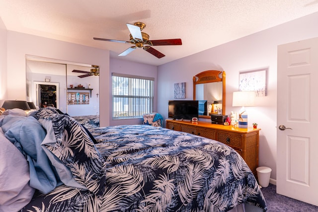 bedroom featuring ceiling fan, a textured ceiling, and carpet