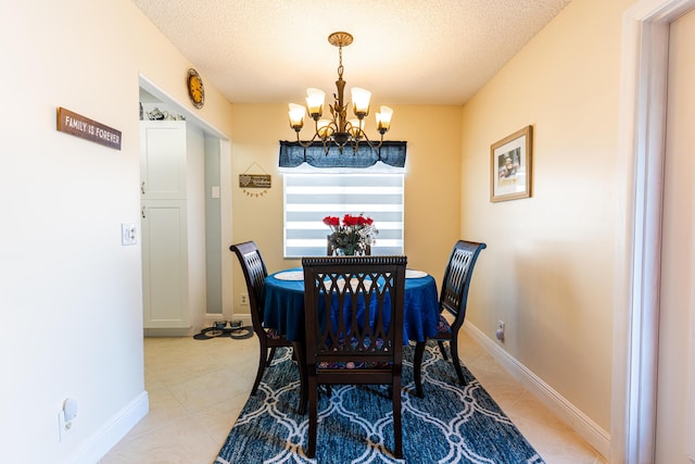 dining area featuring an inviting chandelier, a textured ceiling, and light tile patterned flooring