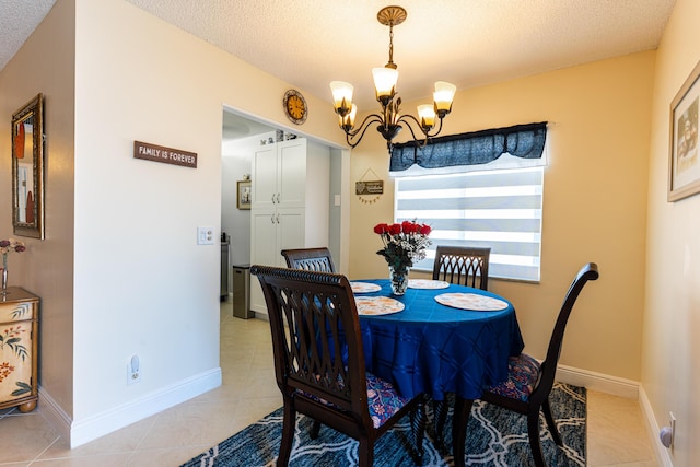 tiled dining room with an inviting chandelier and a textured ceiling