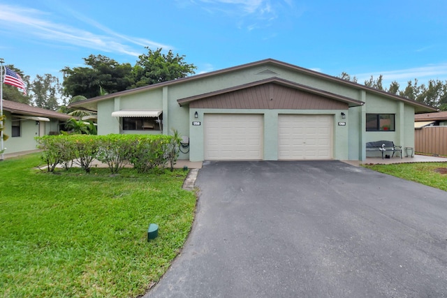 single story home featuring a front lawn and a garage