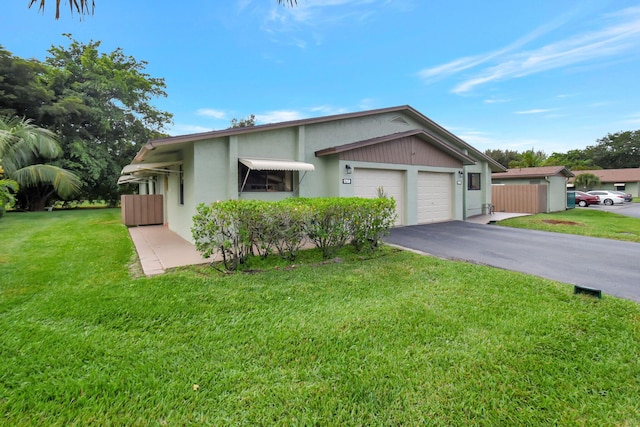 single story home featuring a front lawn and a garage