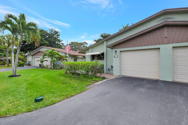 ranch-style home with a garage and a front lawn