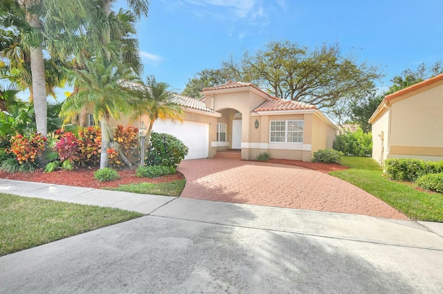 mediterranean / spanish home with a garage and a front yard