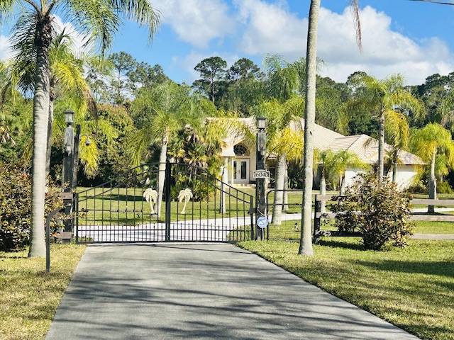 view of gate with a lawn