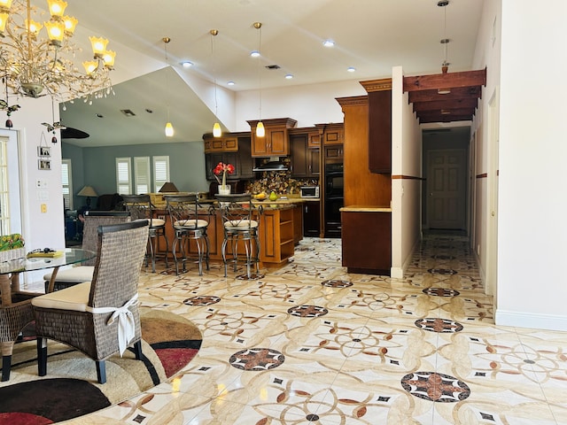 kitchen featuring pendant lighting, black double oven, and a kitchen breakfast bar