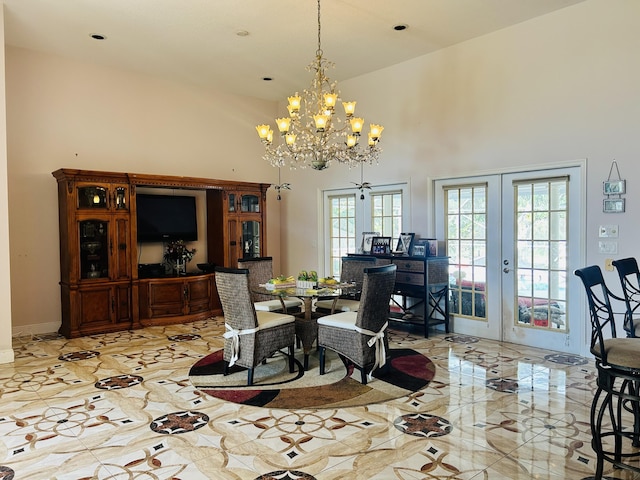 interior space with french doors, a towering ceiling, and a notable chandelier