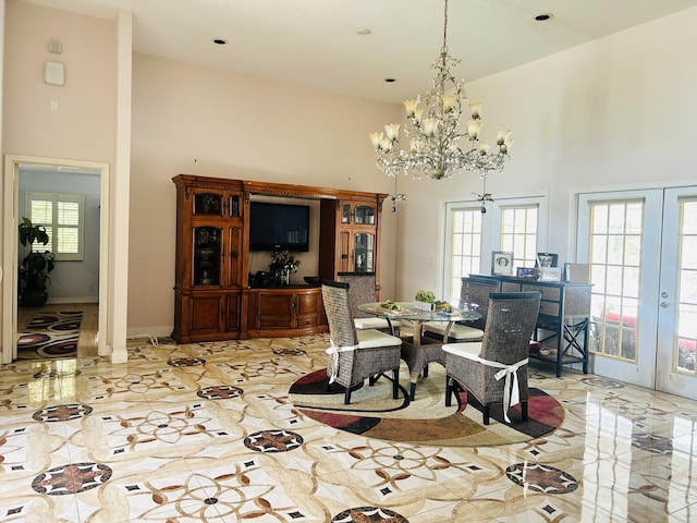 dining space featuring a high ceiling, plenty of natural light, an inviting chandelier, and french doors