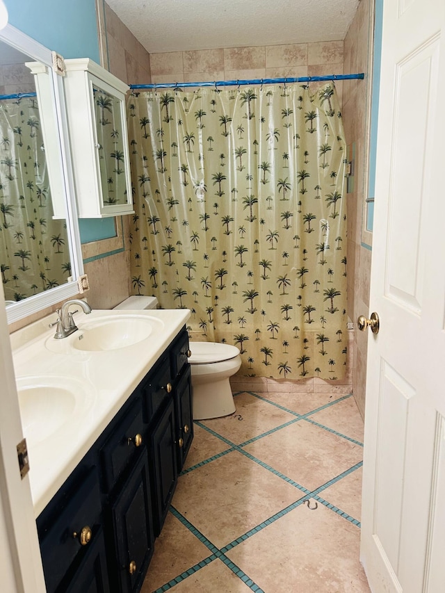 bathroom featuring walk in shower, vanity, toilet, and tile patterned flooring