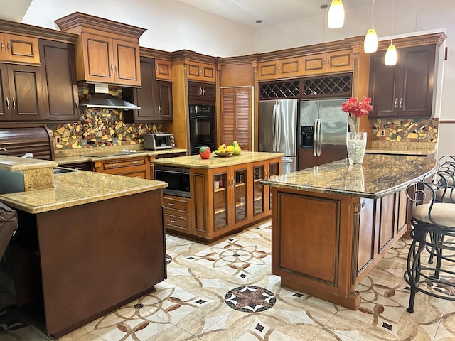 kitchen with wall chimney exhaust hood, tasteful backsplash, decorative light fixtures, a center island, and black appliances