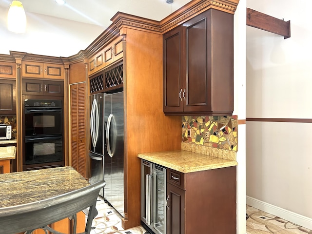 kitchen with wine cooler, light stone countertops, black double oven, and stainless steel refrigerator