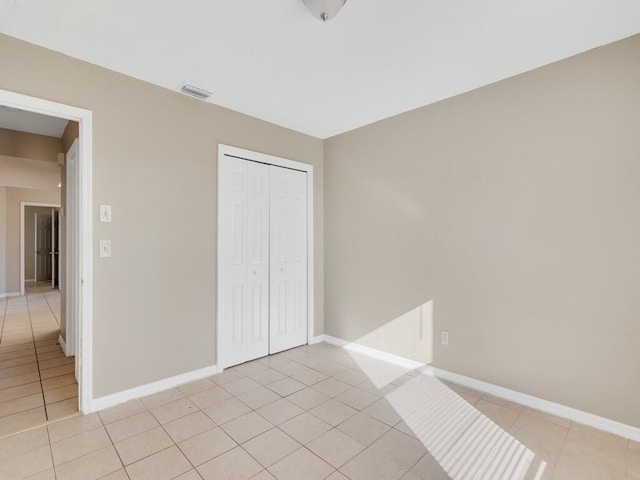 unfurnished bedroom with light tile patterned floors and a closet