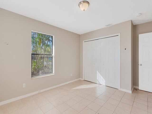 unfurnished bedroom with light tile patterned floors and a closet