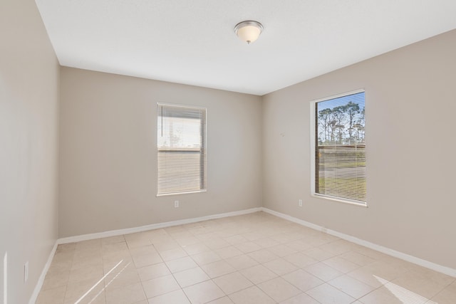 empty room with plenty of natural light and light tile patterned floors