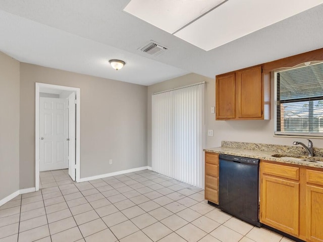 kitchen featuring light stone counters, sink, light tile patterned floors, and dishwasher