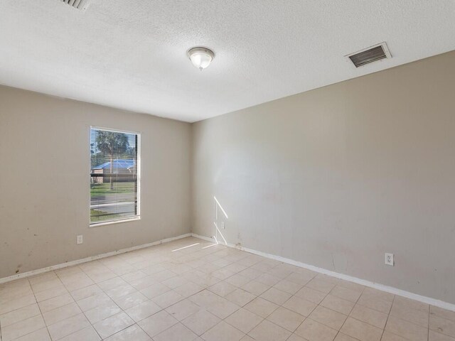 unfurnished room with a textured ceiling