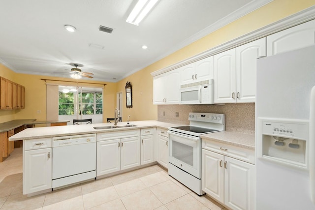 kitchen with sink, white appliances, ornamental molding, white cabinets, and kitchen peninsula