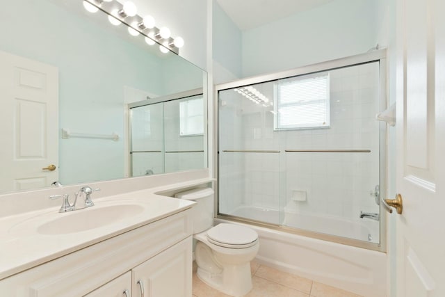 full bathroom featuring tile patterned flooring, bath / shower combo with glass door, vanity, and toilet