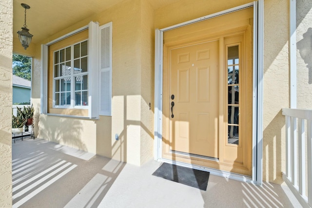 doorway to property with stucco siding and a porch