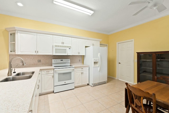 kitchen featuring sink, crown molding, white appliances, light tile patterned floors, and white cabinets