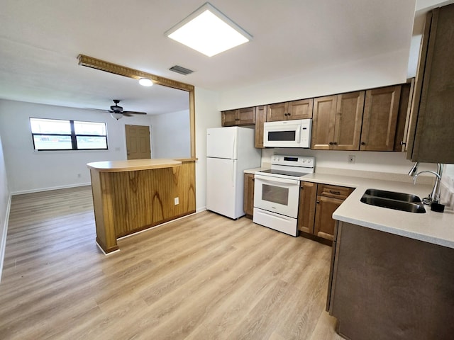 kitchen with sink, white appliances, light hardwood / wood-style flooring, kitchen peninsula, and ceiling fan